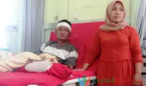 Korban dugaan pembacokan, Samhaji, menjalani perawatan medis di RSUD Pamekasan di dampingi istrinya, Horrida. (Foto. Hasibuddin)