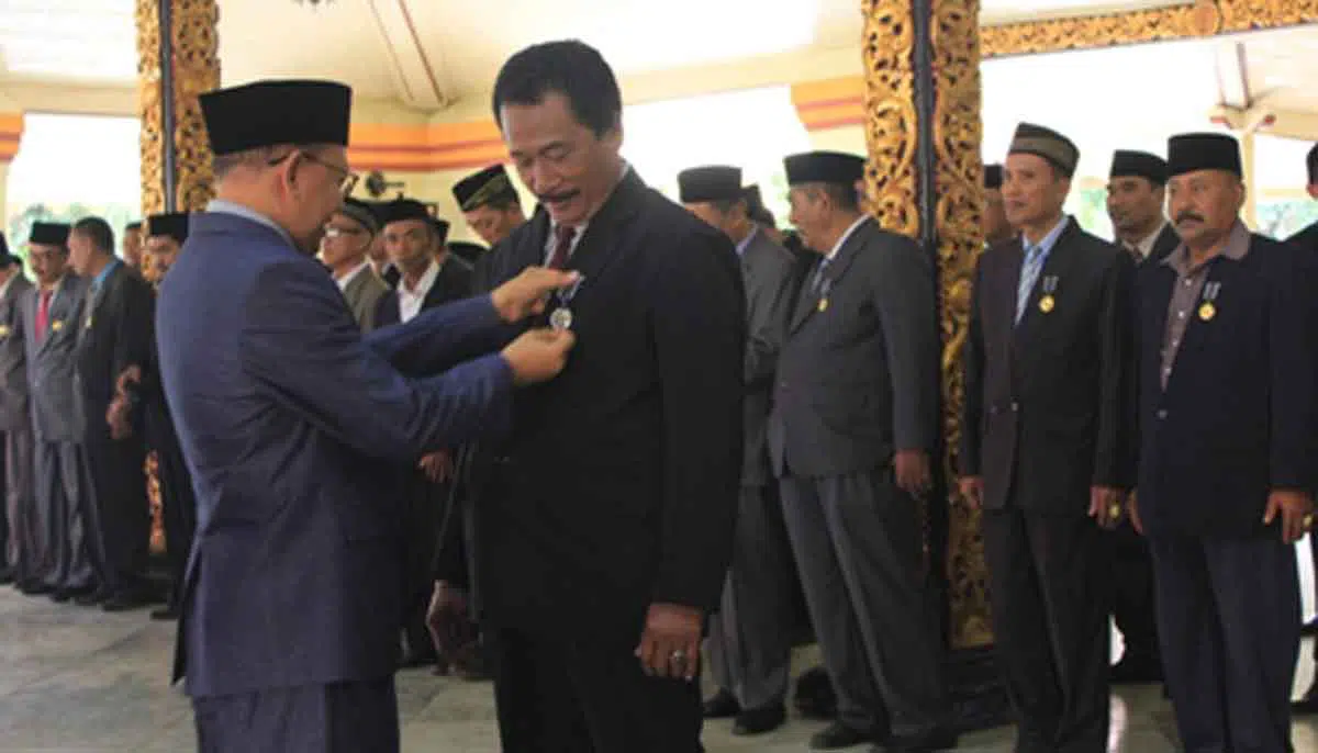 Bupati Sumenep A Busyro Karim menyematkan lencana ke salah satu peserta penerima penghargaan (Foto. Nanik Dwi Jayanti).