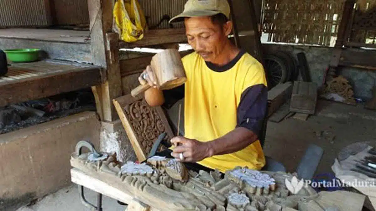 Mengenal Desa Pocong, Dalam Kepemimpinan Wanita Cantik - Portalmadura.com Sujono sedang mengukir kayu yang akan dibuat lemari hias. (Foto: Agus Hidayat)