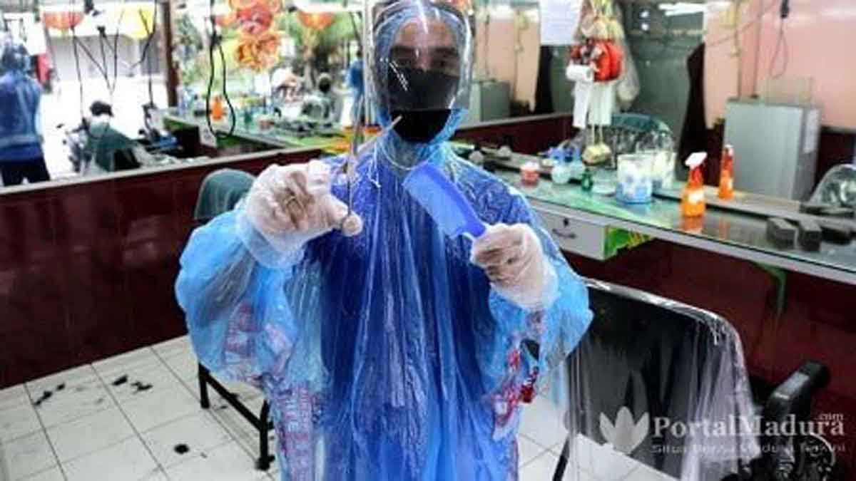 Lindungi Diri, Tukang Cukur Pakai APD Covid-19
