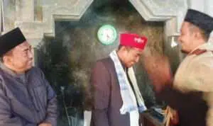 Ketua GMNU Madura saat memakaikan songkok warna merah bertuliskan NU kepada Achmad Fauzi