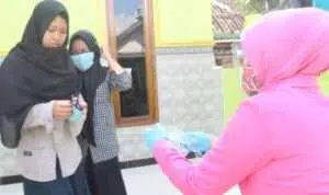 Kanan, Ibu Bhayangkari Cabang Sumenep saat membagikan masker kepada siswa (Foto Istimewa)