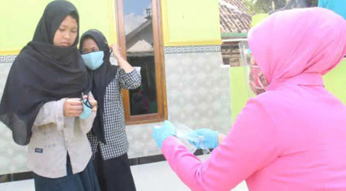 Kanan, Ibu Bhayangkari Cabang Sumenep saat membagikan masker kepada siswa (Foto Istimewa)
