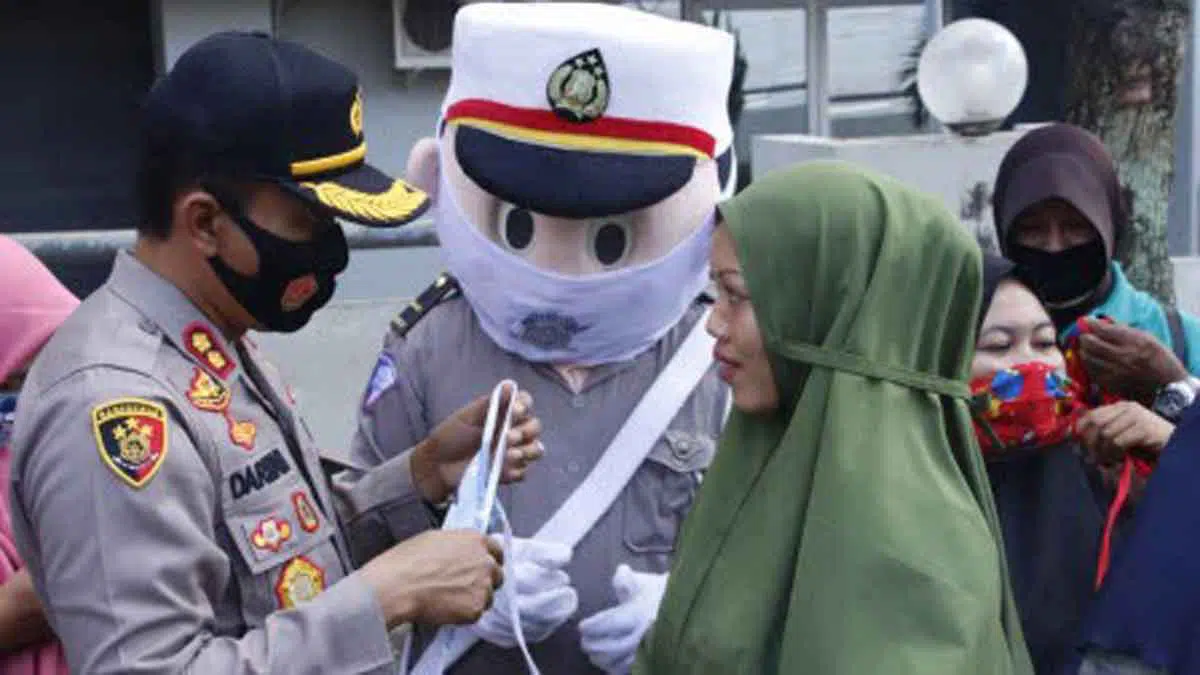 Kiri, Kapolres Sumenep AKBP Darman turun sendiri membagikan masker gratis kepada pengendara. (Foto. Taufikurrahman)