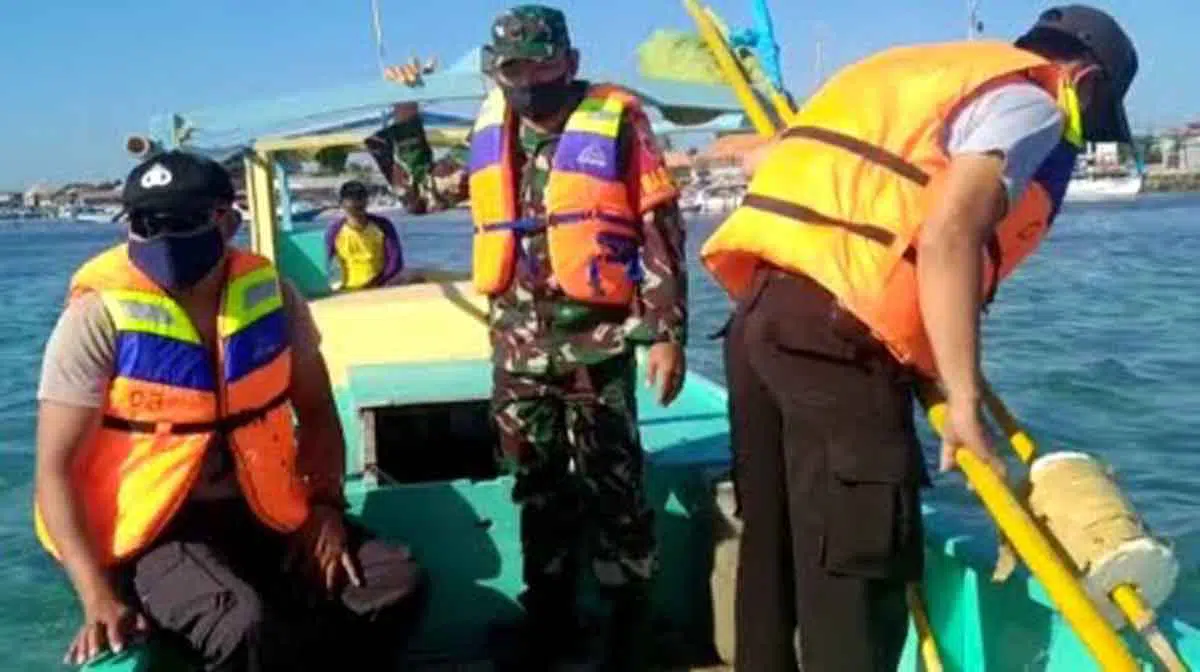 Petugas dari Polsek Sapeken dan TNI setempat melakukan proses pencarian korban hilang akibat KM Obama terbalik dihantam ombak di perairan Pagerungan Kecil, Rabu (26/8/2020) pagi. (Foto Ist for @portalmadura.com)