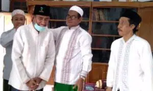 Achmad Fauzi dapat hadiah kopiah hitam berlambang Generasi Muda Nahdlatul Ulama (GMNU) dari pengasuh Pondok Pesantren (Ponpes) Al-Is’af, KH. Khalilullah MZ.