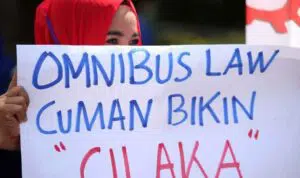 dok. salah satu buruh saat aksi memegang poster (detik.com)