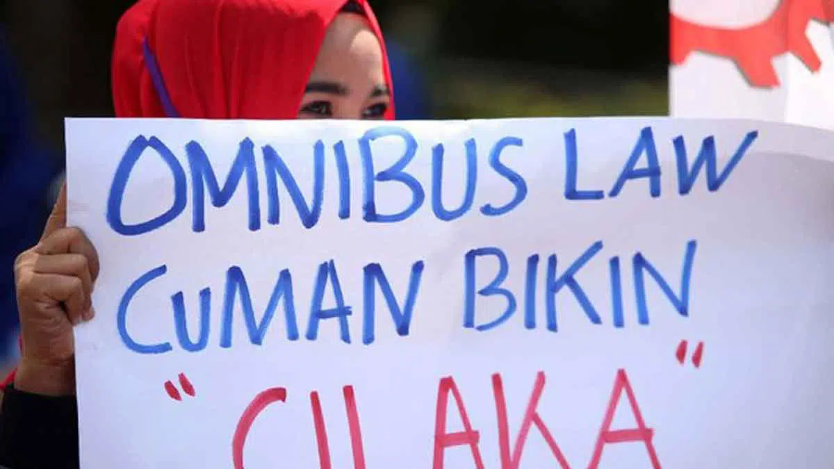 dok. salah satu buruh saat aksi memegang poster (detik.com)
