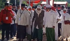 Kiai Muqsith tampak mengenakan jas warna coklat, serban putih dan sarung hijau berada di antara rombongan yang mengantarkan Fauzi-Eva (Foto. Taufikurrahman @portalmadura.com)