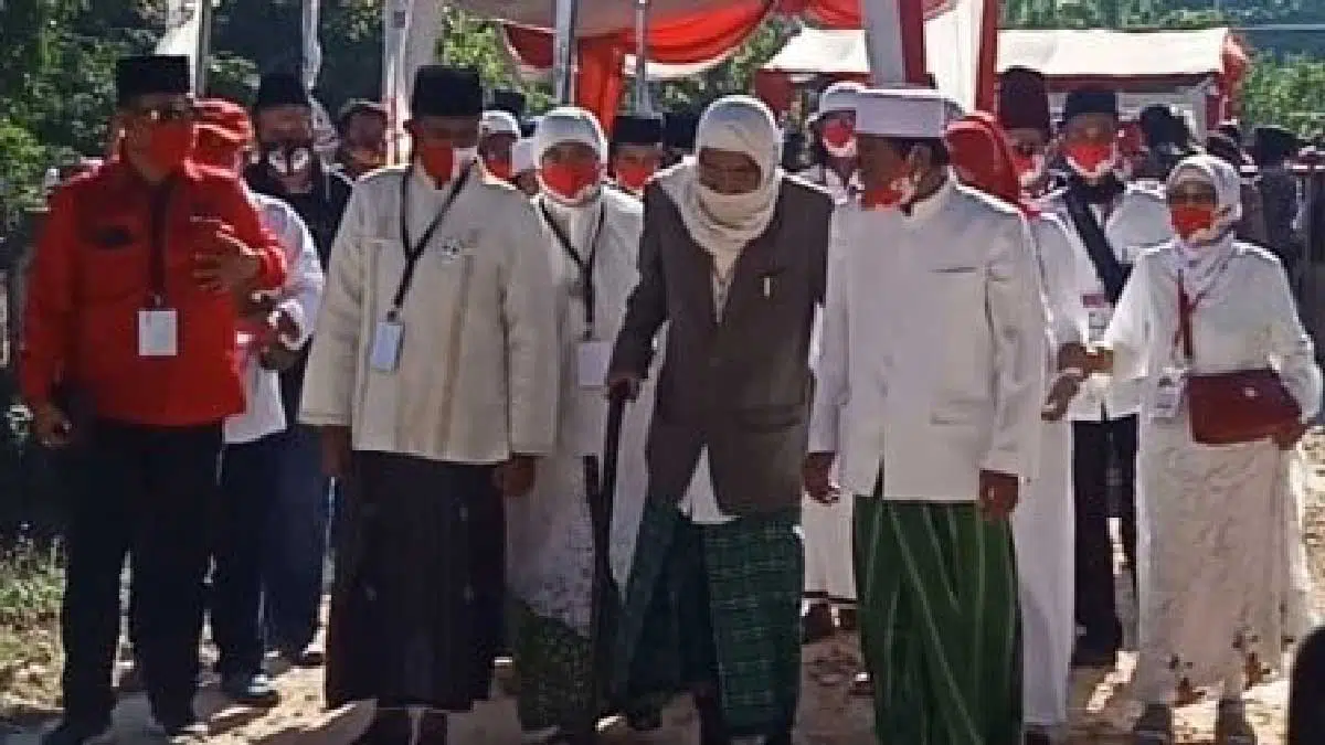 Kiai Muqsith tampak mengenakan jas warna coklat, serban putih dan sarung hijau berada di antara rombongan yang mengantarkan Fauzi-Eva (Foto. Taufikurrahman @portalmadura.com)