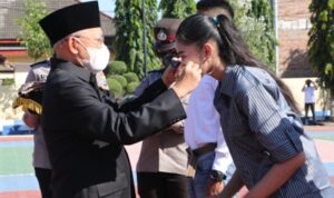 Simbolis, Bupati Sumenep A Busyro Karim memasangkan masker pada Apel Kampanye Penggunaan Masker dan Deklarasi Anti Narkoba di halaman Mapolres Sumenep, Kamis (10/9/2020). (Foto. Humas Pemkab Sumenep for @portalmadura.com)