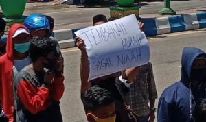 Peserta aksi membawa karton bertuliskan "tembakau murah gagal nikah" (Foto @portalmadura.com)