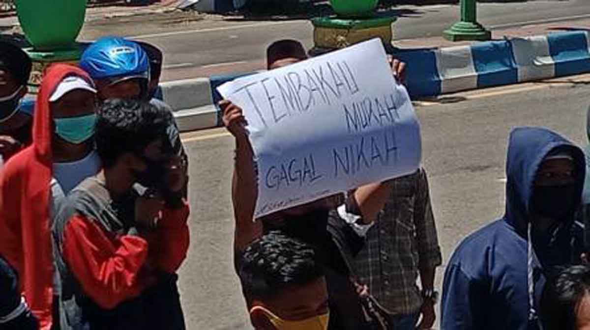 Peserta aksi membawa karton bertuliskan "tembakau murah gagal nikah" (Foto @portalmadura.com)