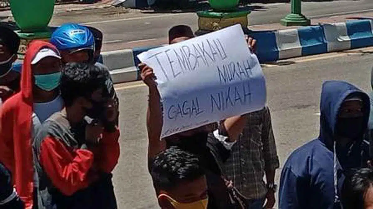 Peserta aksi membawa karton bertuliskan "tembakau murah gagal nikah" (Foto @portalmadura.com)