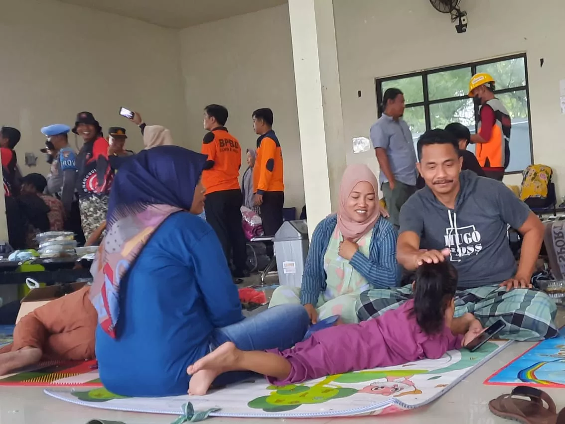 Sejumlah calon penumpang kapal yang tertahan di Pelabuhan Kalianget akibat penundaan pemberangkatan kapal, duduk lesehan sambil bercengkerama, Jumat (30/12). (Slamet HD/PortalMadura.Com)