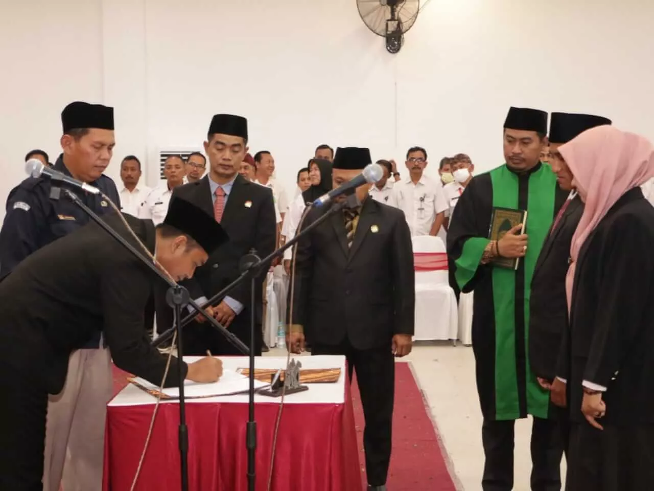 Ketua KPU Sumenep, Rahbini (kiri) menandatangani berita acara pelantikan 135 anggota PPK Pemilu 2024 di aula gedung pertemuan di Jalan KH Mansyur, Kecamatan Kota, Rabu (4/1). (IST/PEMKAB SUMENEP)