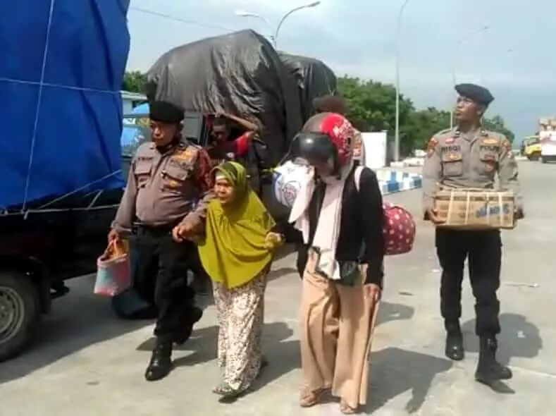 Anggota Polres Sumenep membantu mengangkut barang bawaan calon panumpang yang akan naik Kapal DBS III di Pelabuhan Kalianget, Jumat (6/1). (IST/POLRES SUMENEP)